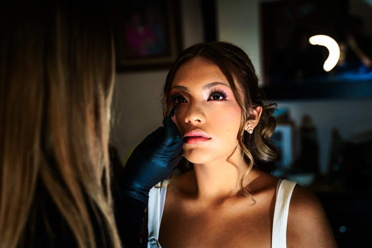 Aplicación de maquillaje durante la preparación de una quinceañera.