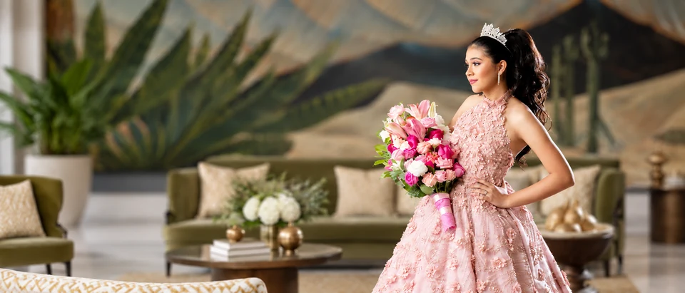Quinceañera con corona y ramo de flores.