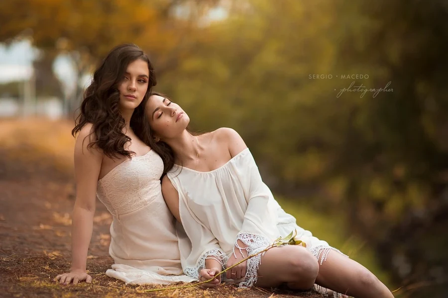 Dos personas con cabello ondulado posan juntas al aire libre.