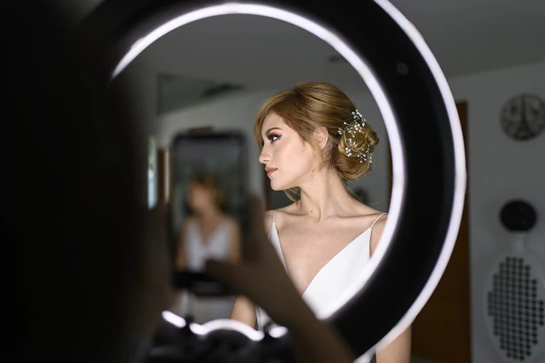 Perfil con cabello recogido y tocado, enmarcado por un aro de luz.